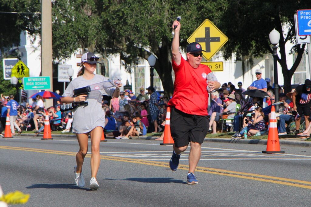 Newberry Mayor Tim Marden and his daughter, Nicole, toss out t-shirts and amp up the crowd at the start of the Newberry Fourth of July Parade. 