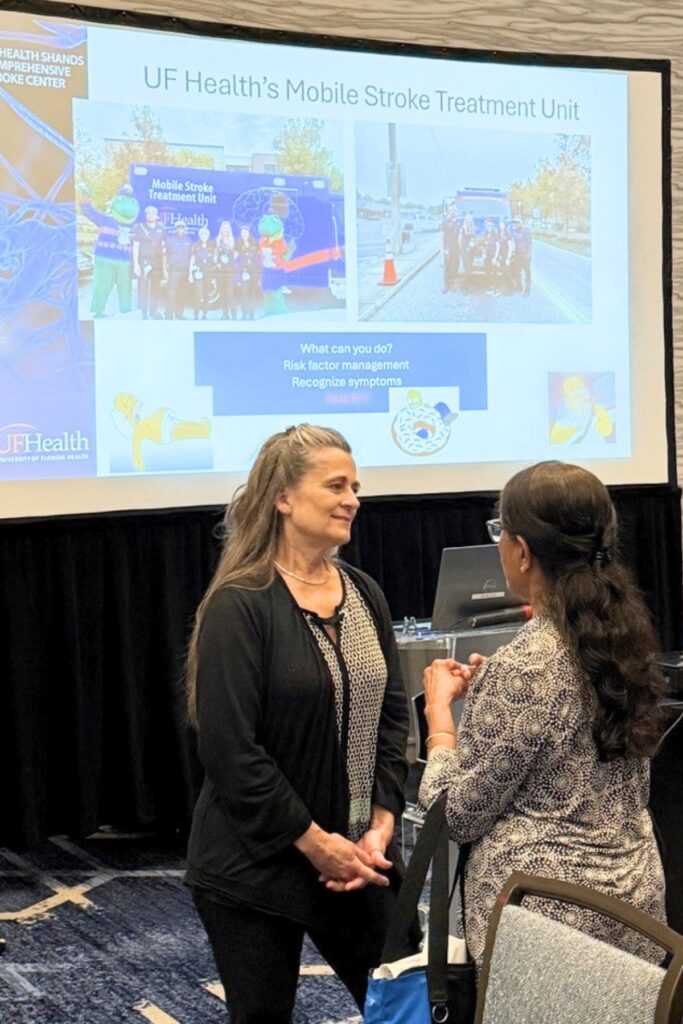 Nurse practitioner Windy Purtlebaugh speaks with an attendee at a recent talk she delivered on strokes and heat stroke. Photo by UF Health