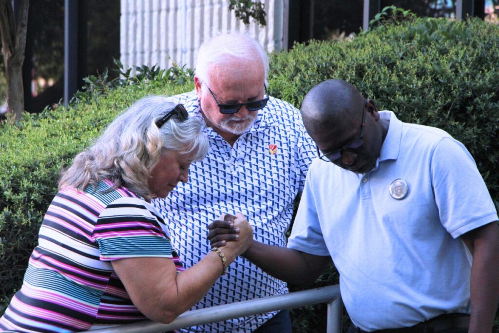 Residents pray over High Springs Police Chief Antoine Sheppard (right) following his reinstatement. Photo by Lillian Hamman (1)