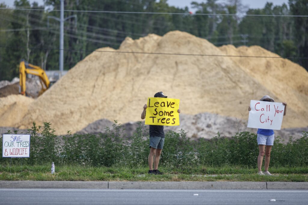 Riceland residents protest outside the construction site for Gainesville Fire Station 9 along Archer Road in Gainesville on Wednesday. Neighbors gathered to oppose the clear-cutting of the wooded property, saying the loss of the trees has changed the character of their neighborhood.