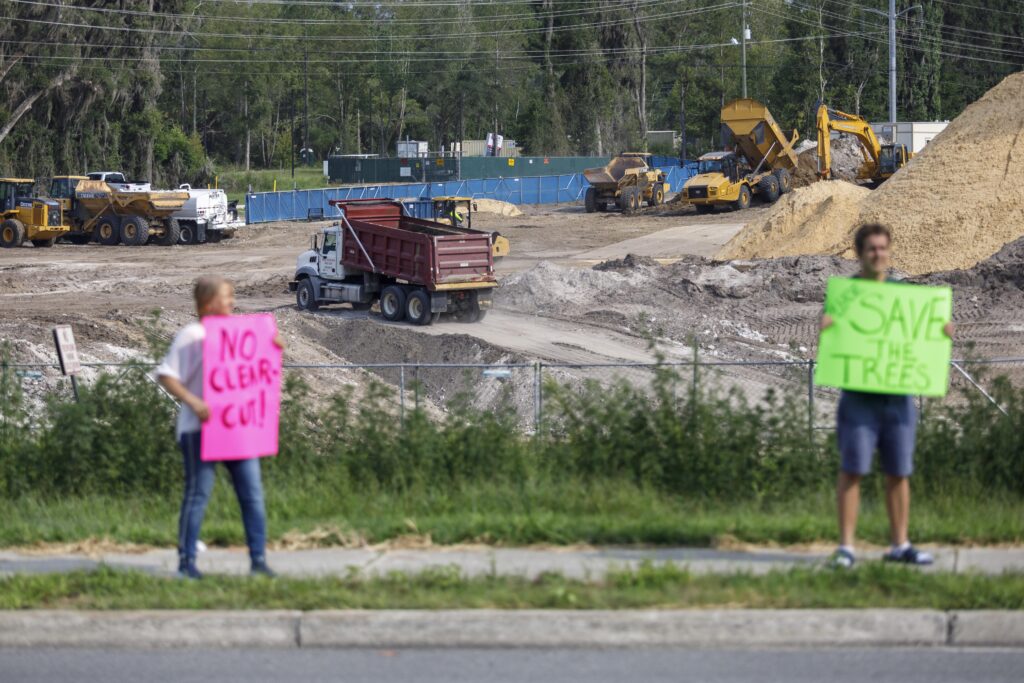 Residents stand along SW Archer Road in Gainesville on Wednesday, protesting the clear-cutting of the future site of Fire Station 9.