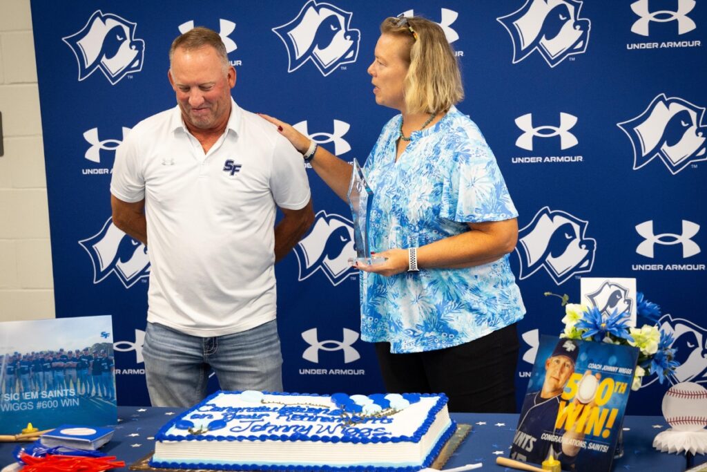 Santa Fe College Athletic Director Chanda Stebbins speaks about Coach Johnny Wiggs during his retirement celebration at the Santa Fe College Gymnasium lobby on Wednesday.