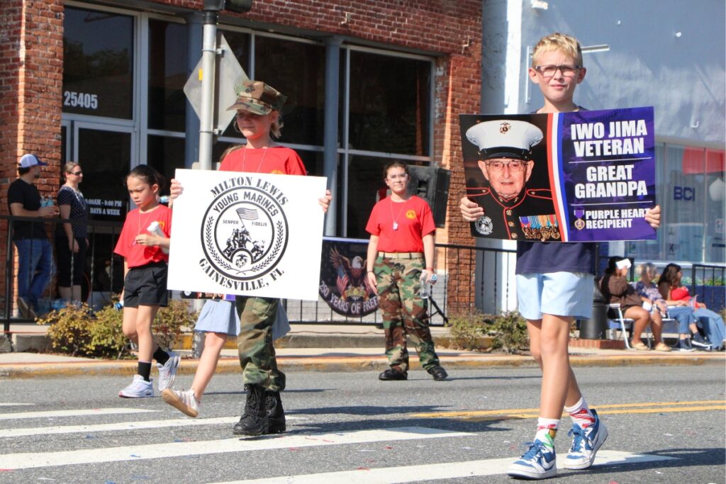 The Milton Lewis Young Marines marched along in the parade with posters of family veterans. 