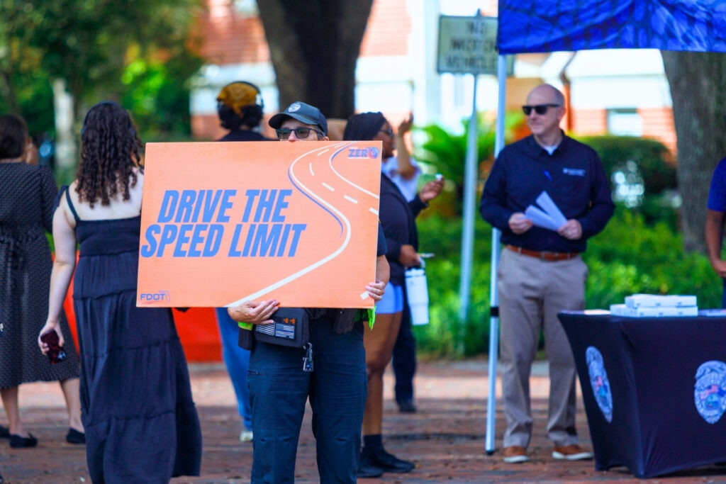 A sign promoting pedestrian safety is displayed during a University of Florida pedestrian and bicycle safety event Monday at Newell Gateway in Gainesville. The event included bicycle registration, free helmets and lights and safety information.