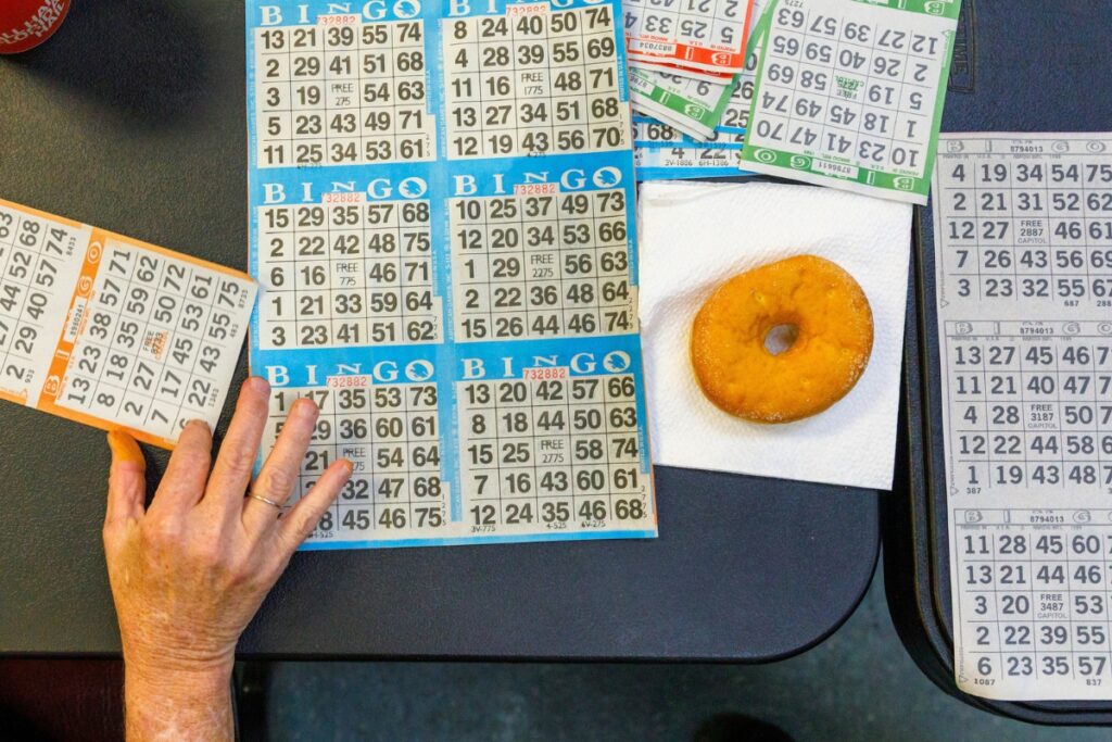 Bingo cards are scattered across a table during a Sunday afternoon game at Veterans of Foreign Wars Post 2811 off Waldo Road in Gainesville, Florida. Players often decorate their tables with personal items and good-luck charms.