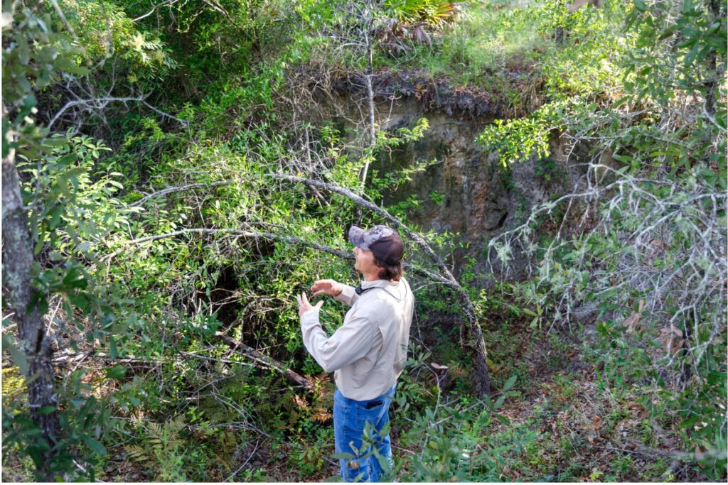 Cully Lord of the University of Florida's IFAS program stands beside one of several sinkholes on a newly acquired property near Parker Road. Lord manages nearly 2,600 acres of forest for UF/IFAS and says overseeing the land has been a rewarding challenge.