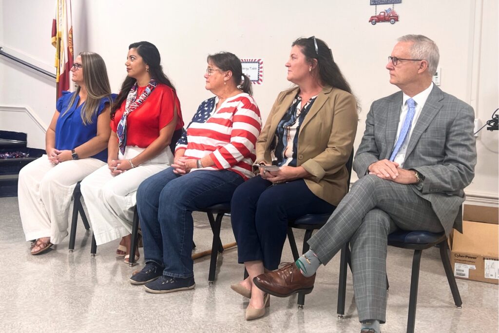 Current and former Newberry Community School Board members listen as Board Chair Derek Danne gives remarks at the ribbon cutting. Photo by Nick Anschultz