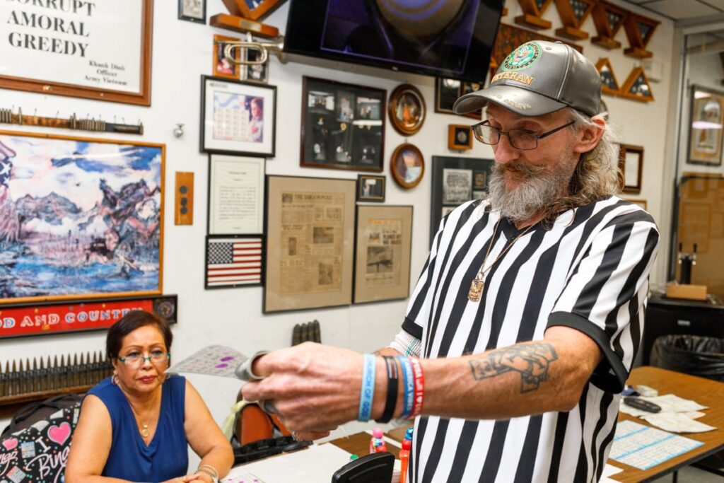 Danny Guyer, known as the 'court jester,' of Bingo checks a participants card to ensure it matches the correct numbers. Photo by Walker Smith