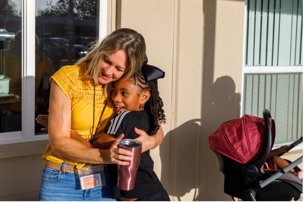 Kara Huff embraces a returning student on the first day of school at Oak View K-8. Photo by Walker Smith