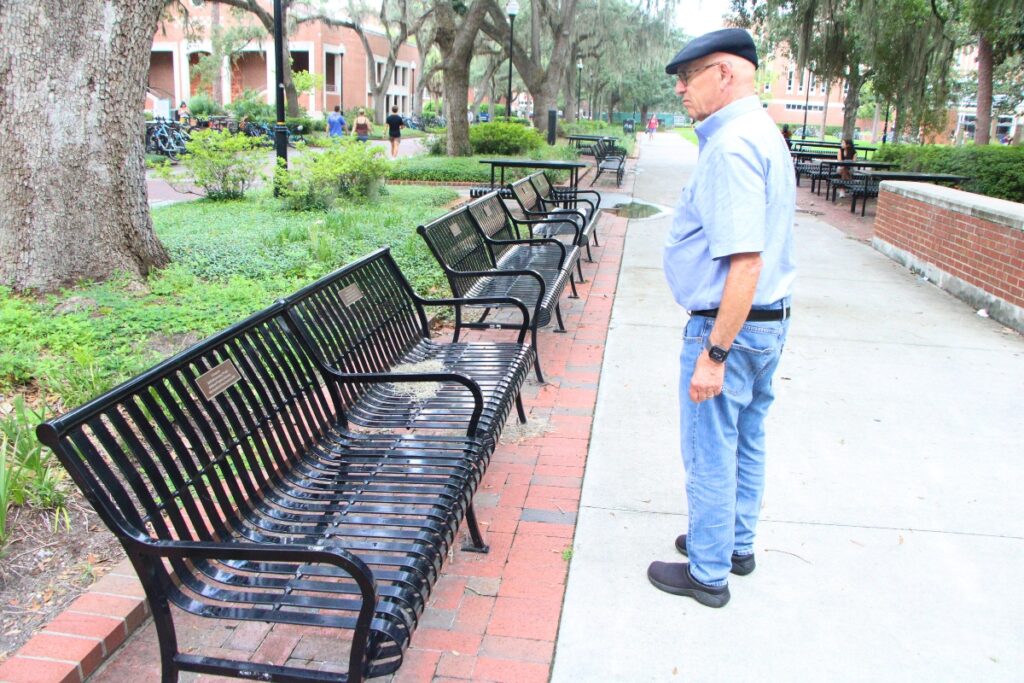 Krishna Lunch Senior Advisor Bob Cohen reflects on benches at UF's Plaza of The Americas donated in honor of the organization. Photo by Lillian Hamman