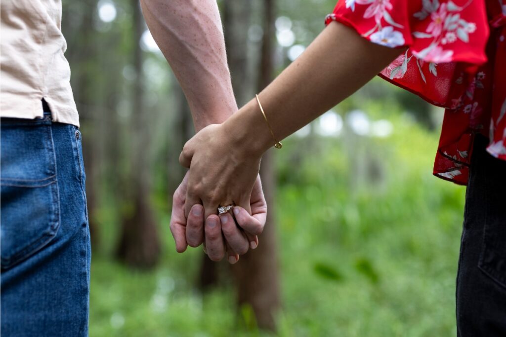 Holding hands with an engagement ring