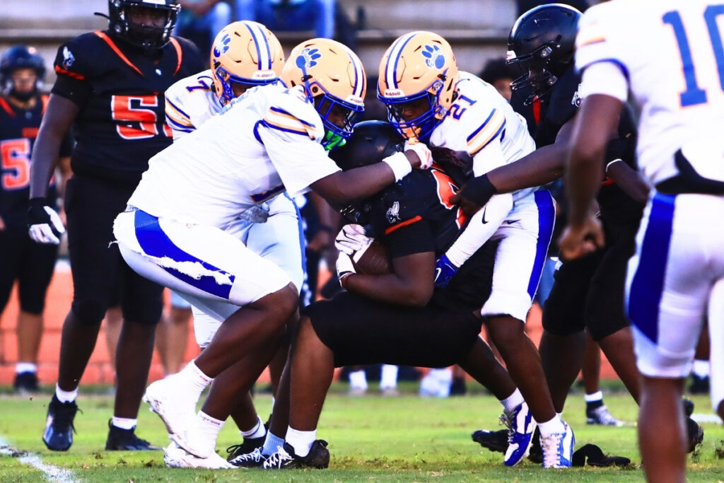 Newberry's Karter Jelks (13) and Kedrian Robinson (21) bring down Hawthorne's Derryek Gillins (25) in the first quarter on Friday. Photo by C.J. Gish