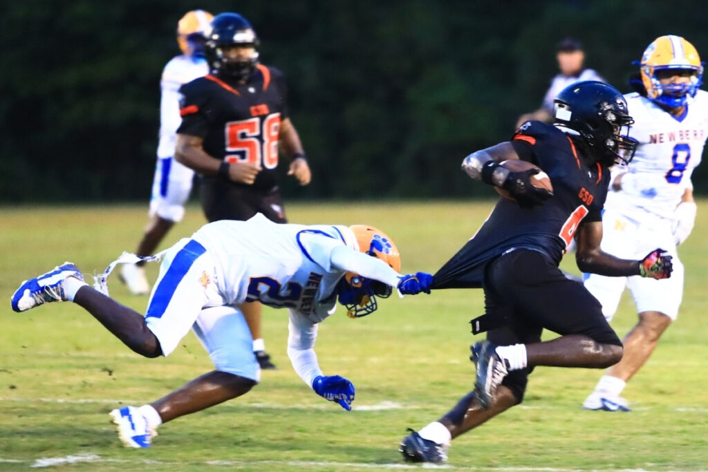 Newberry's Kedrian Robinson (21) slows up Hawthorne's Dakarai Wiggins (4) on Friday. Photo by C.J. Gish