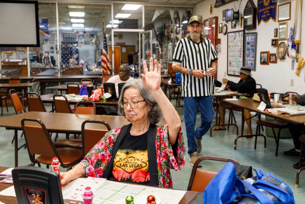Participants compete during a Sunday afternoon bingo game at VFW Post 2811 in Gainesville. Players raise their hands when they believe they have completed a winning pattern on their cards.