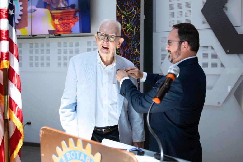Ryan Thompson, a Past President of the Rotary Club of Gainesville and Chair of the SAS Committee this year, places an award pin on Roy Hunt’s lapel. Photo by Jamey Harvey