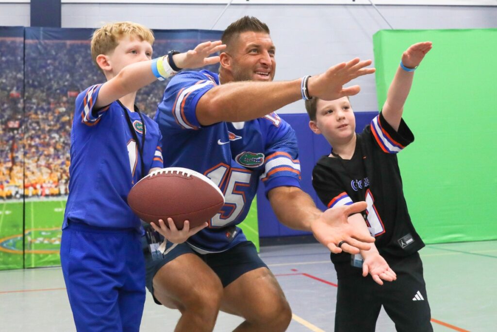 Tim Tebow poses for a photo with young fans during the Florida Legends event at the Alachua County Sports & Events Center on Sunday in Gainesville. Photo by Walker Smith