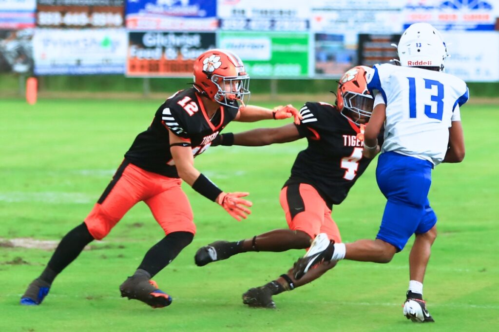 Trenton's Dylan Specht (12) and Jeremiah Settles (4) pursue an Interlachen receiver on Friday. Photo by C.J. Gish