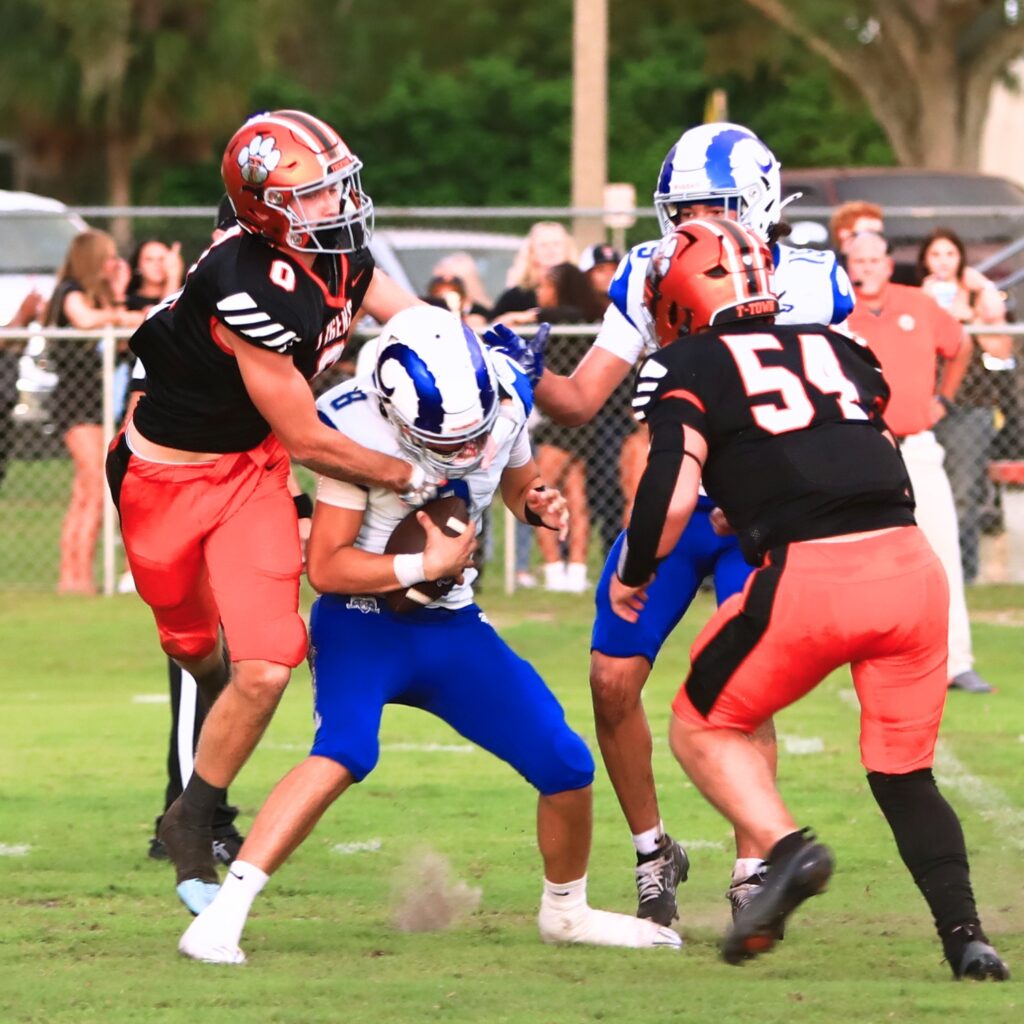 Trenton's Trent Richburg (0) and Michael Pate (54) converge on Interlachen's quarterback for a sack on Friday. Photo by C.J. Gish