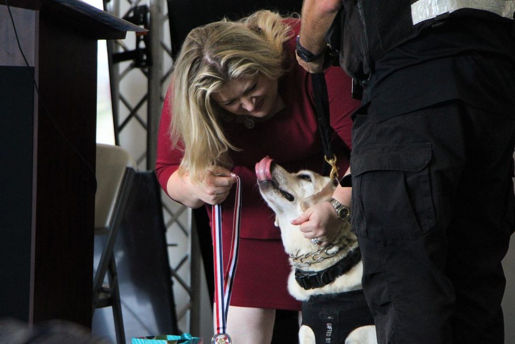 U.S. Representative Kat Cammack places a medal around Beamer at her retirement.