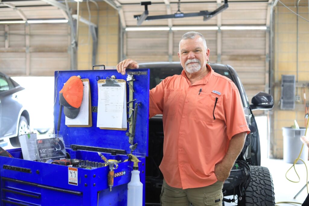 Dave Barber Jr. stands by a large tool chest inside the auto paint and body shop that he runs.