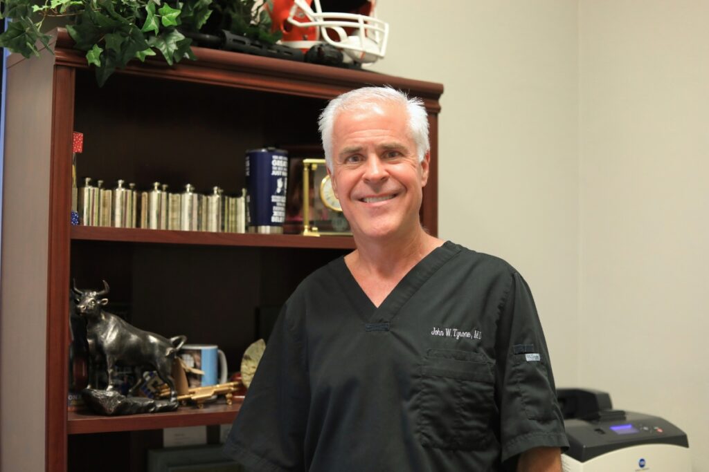 Dr. John Tyrone stands behind his desk in his Gainesville office.