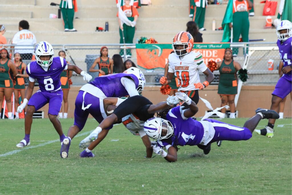 Gainesville High School defenders combine to take down Eastside's Jameer McCarthy (1) on a catch for a first down on the opening drive. Photo by Seth Johnson