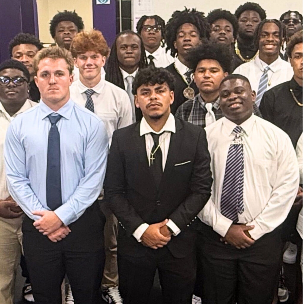 Gainesville senior Sebastian Jimenez (center in black suit) with the Hurricanes football team. Courtesy of Ashour Peera