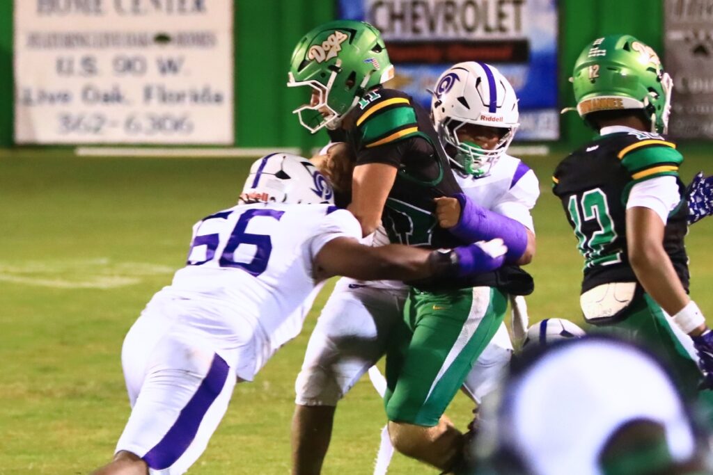 Gainesville's Zaire Francis (4) and Zaivrin Chess (66) take down Suwannee's Haigen Johnson (11) on Friday. Photo by C.J. Gish
