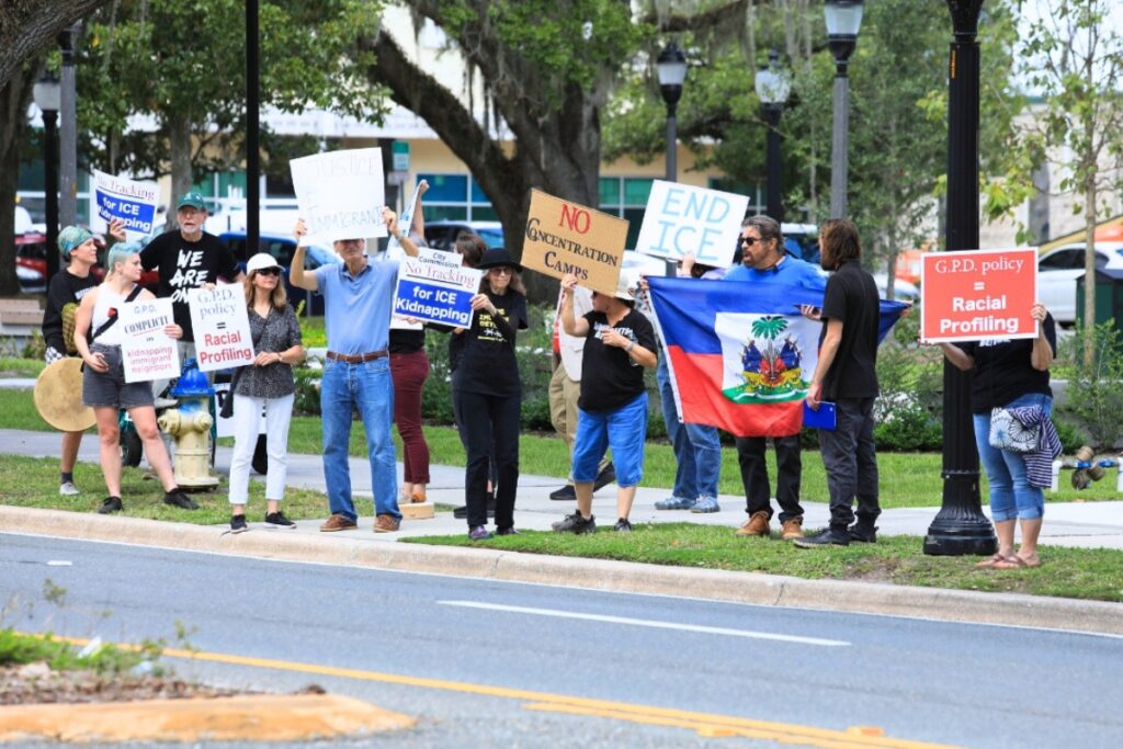 Protesters hold signs along University Avenue before Thursday's Gainesville City Commission meeting. Photo by Seth Johnson