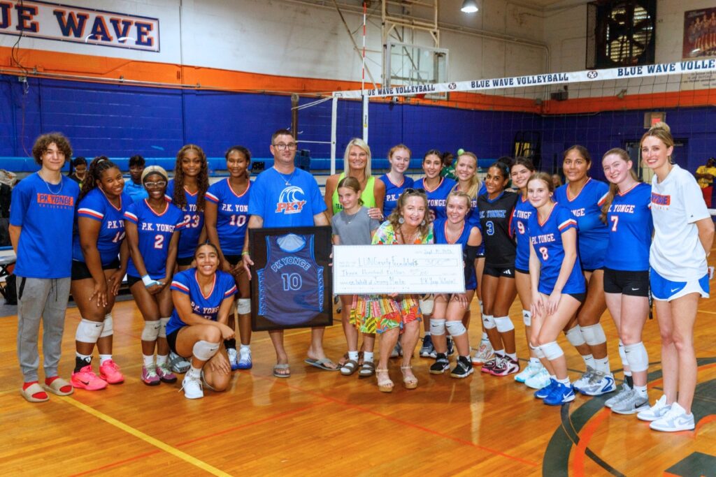 The P.K. Yonge volleyball team presents a check to the Martin family in honor of Jeremy Martin, a P.K. Yonge alumnus. Photo by Walker Smith
