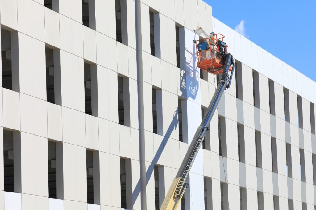 A construction worker spray paints the side of the under-construction courthouse parking garage. Photo by Seth Johnson