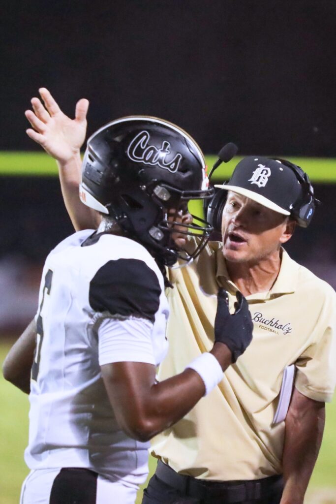 Buchholz head coach Mark Whittemore speaks with Dominik Harvey during the game Thursday night at Santa Fe High School.
