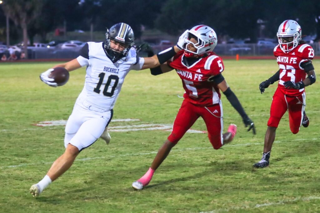 Buchholz senior Koy Frier blocks a Santa Fe defender while advancing down the field Thursday night. Photo by Walker Smith