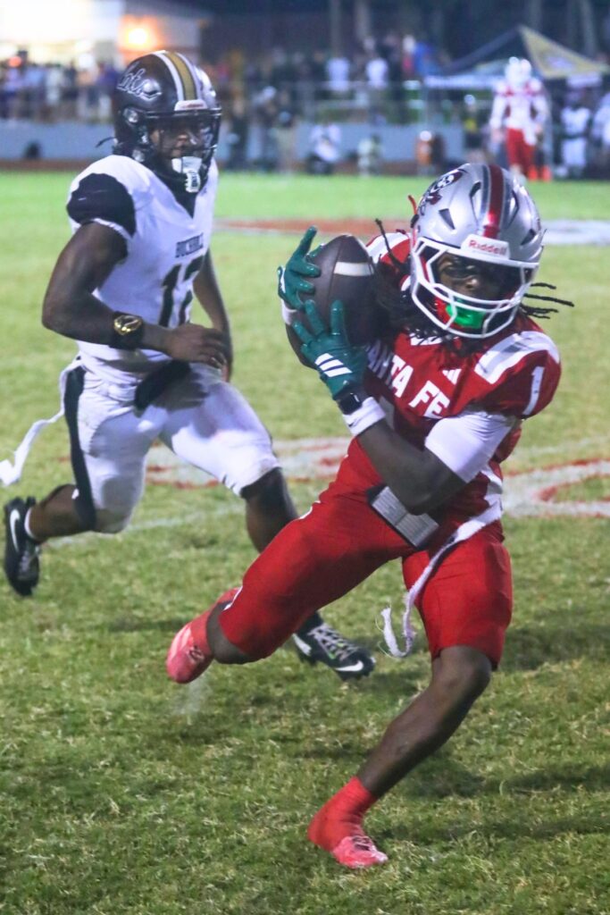 Santa Fe’s Jadathun Bryant receives the ball as the Buchholz defense attempts to block him. Photo by Walker Smith