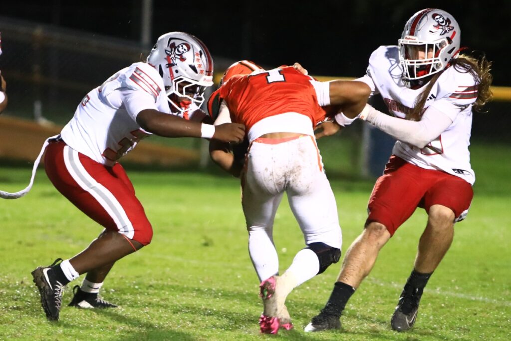 Santa Fe's Jamel Smith (32) and Mason Nipper (45) bring down Eastside's Jayce Starke (4) in the second quarter on Thursday. Photo by C.J. Gish